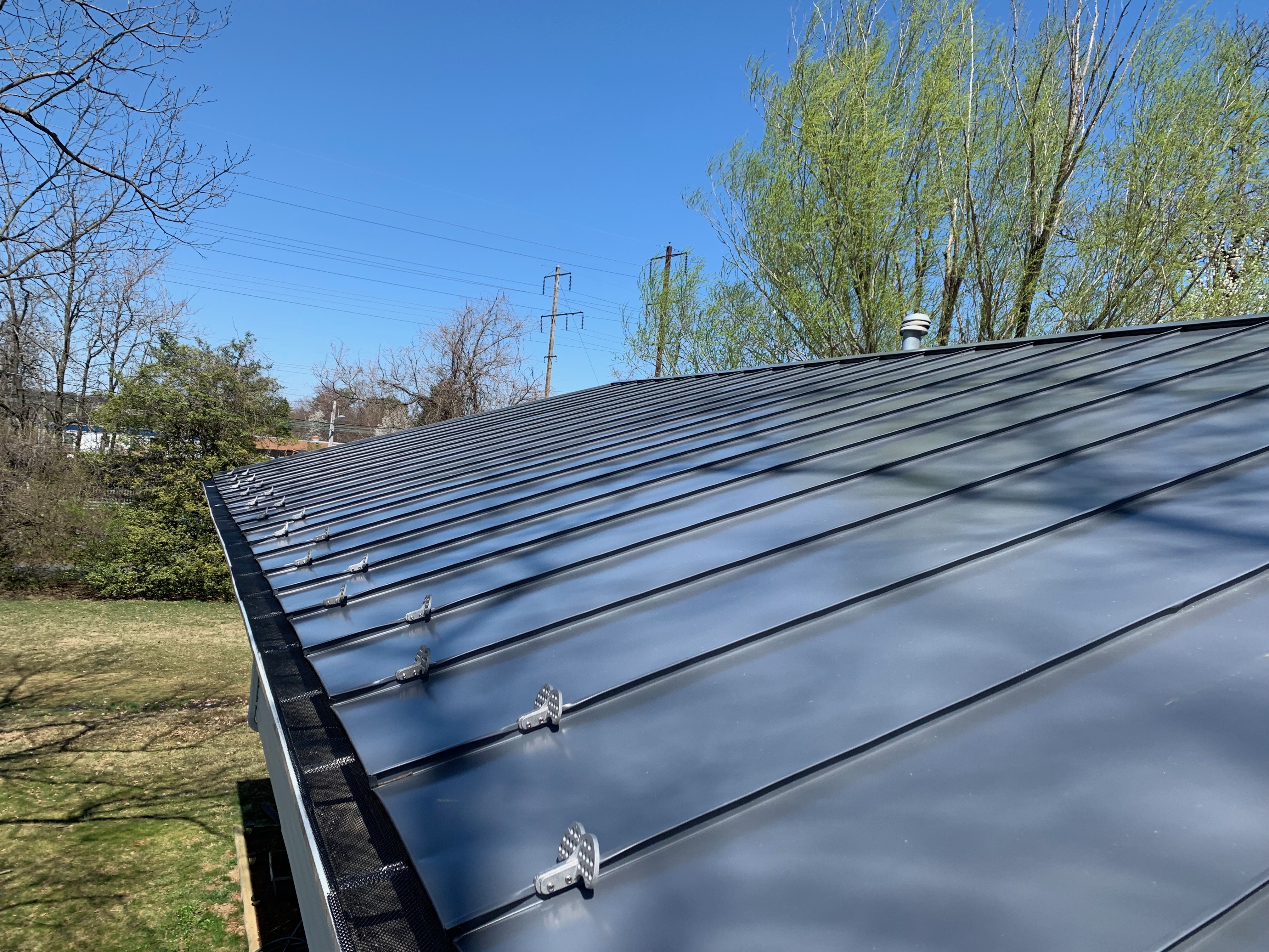 Dark standing seam metal roof against blue sky in Northern Virginia